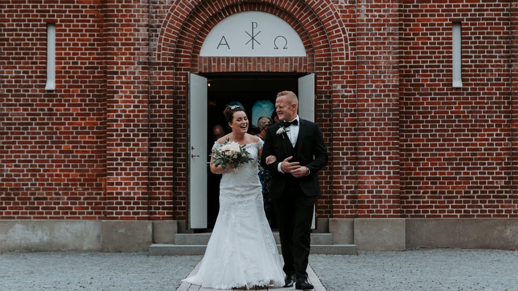 Brud og far på vej ud af kirkedøren på bryllupsdagen