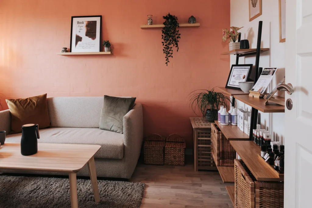 Konsultationsrum hos Wetalia med sofa og terracottafarvet væg