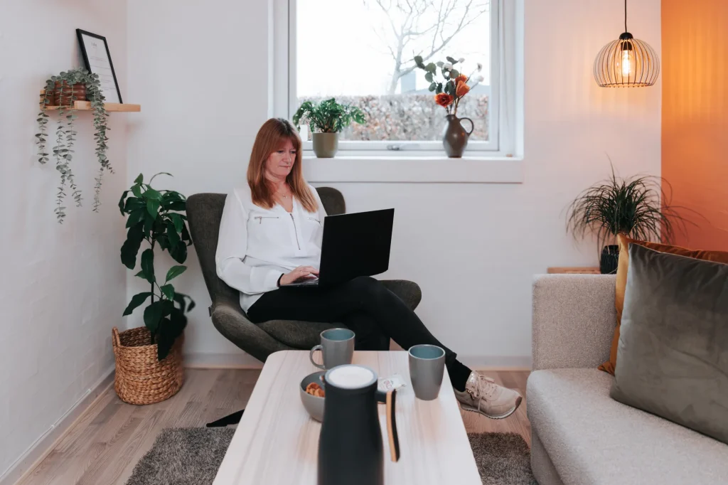Laila Bill fra Wetalia sidder med bærbar i sit lyse konsultationsrum