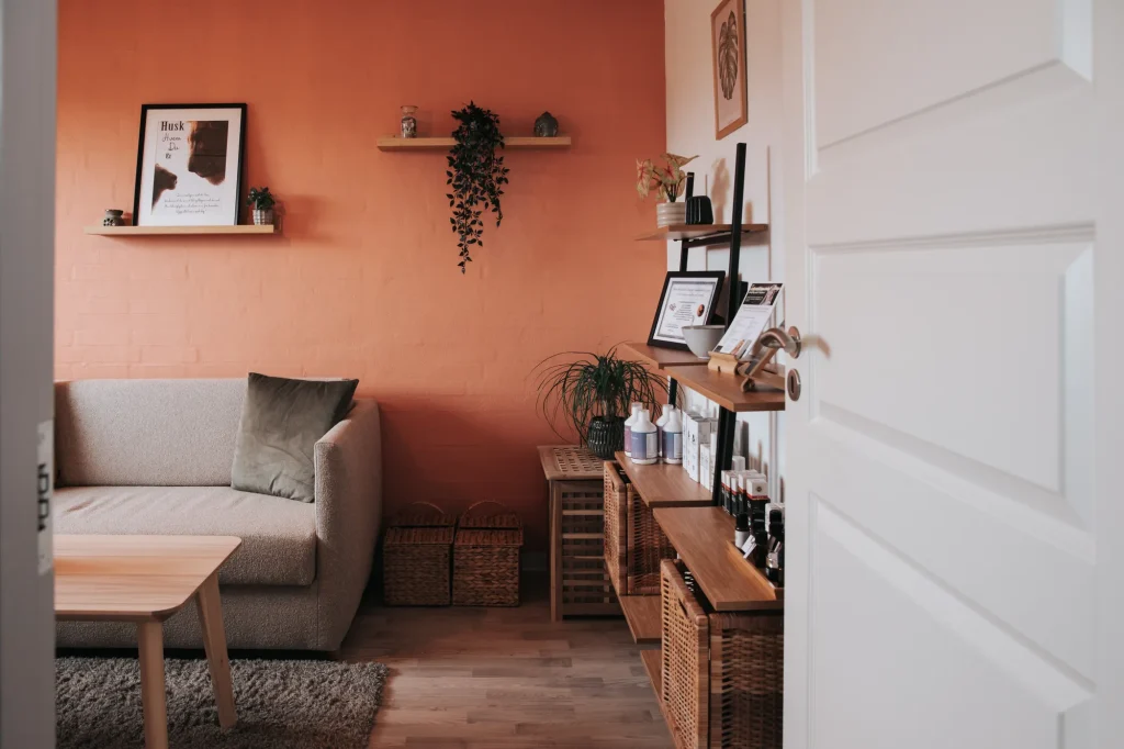 Hyggeligt konsultationsrum med sofa og terracotta væg hos Wetalia