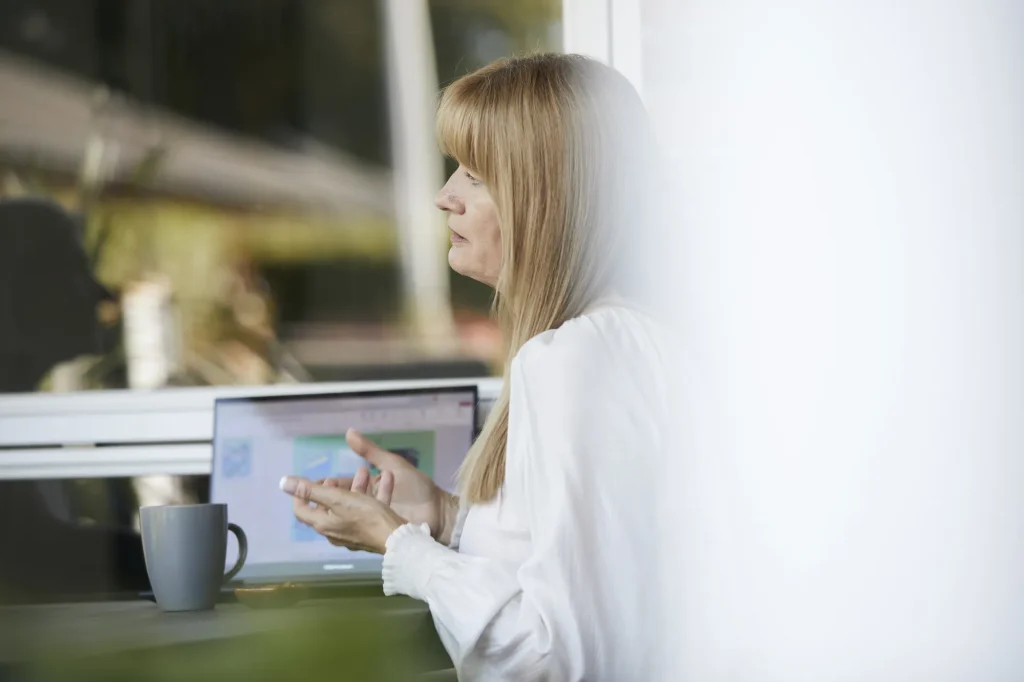 Laila Bill arbejder ved computer ved vinduet