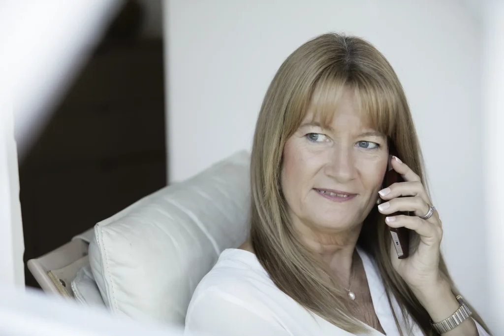 Laila Bill taler i telefon i sofaen