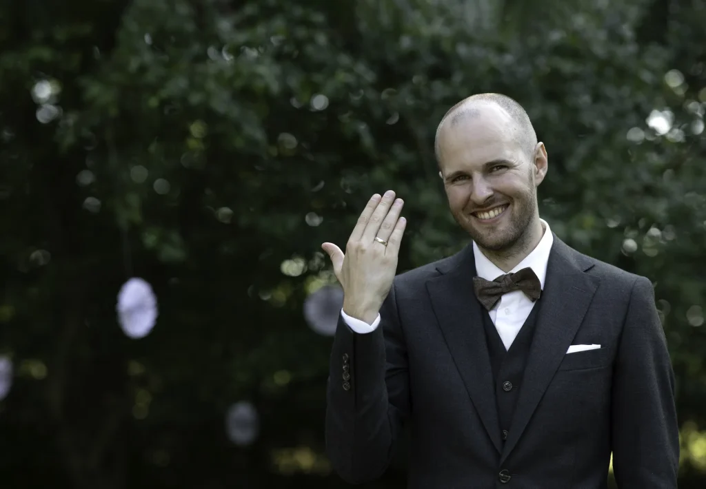 Smilende brudgom viser sin vielsesring