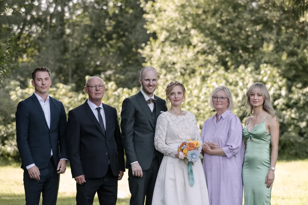 Brudepar med familie – gruppebillede ved bryllup