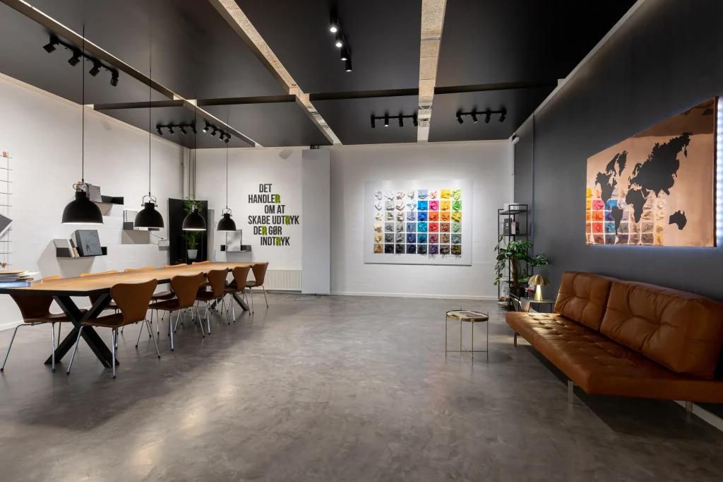 ReklameTryks showroom med langt mødebord og orange læderbænk