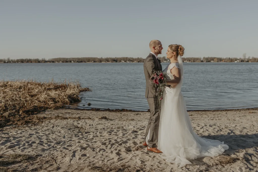 Brudepar ved søen med blå himmel