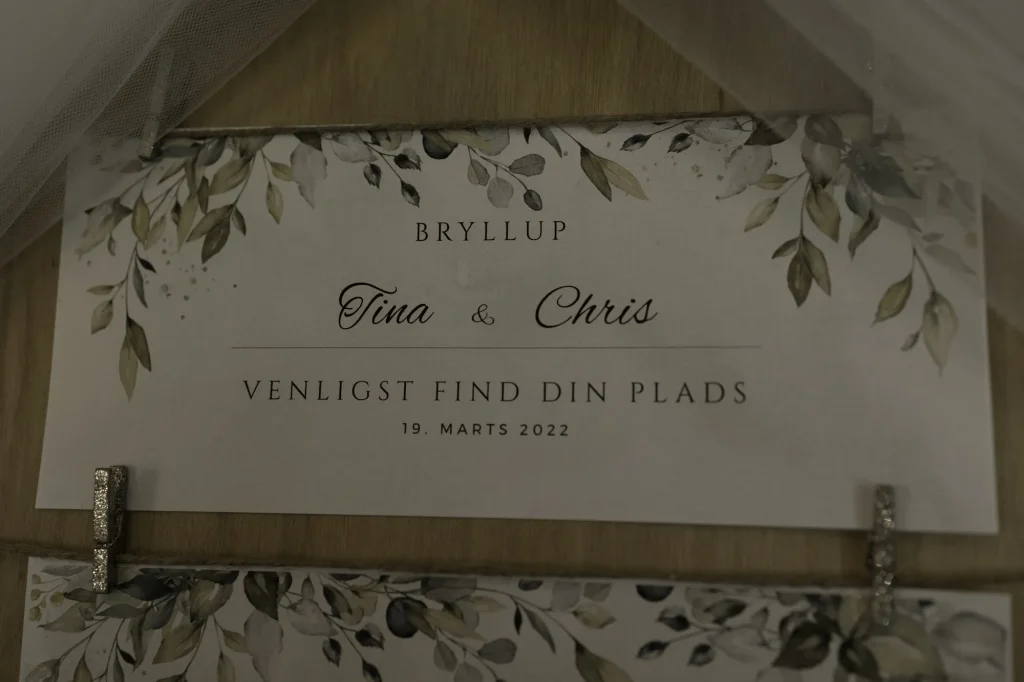 Bordplan-skilt til bryllup med teksten 'Venligst find din plads'