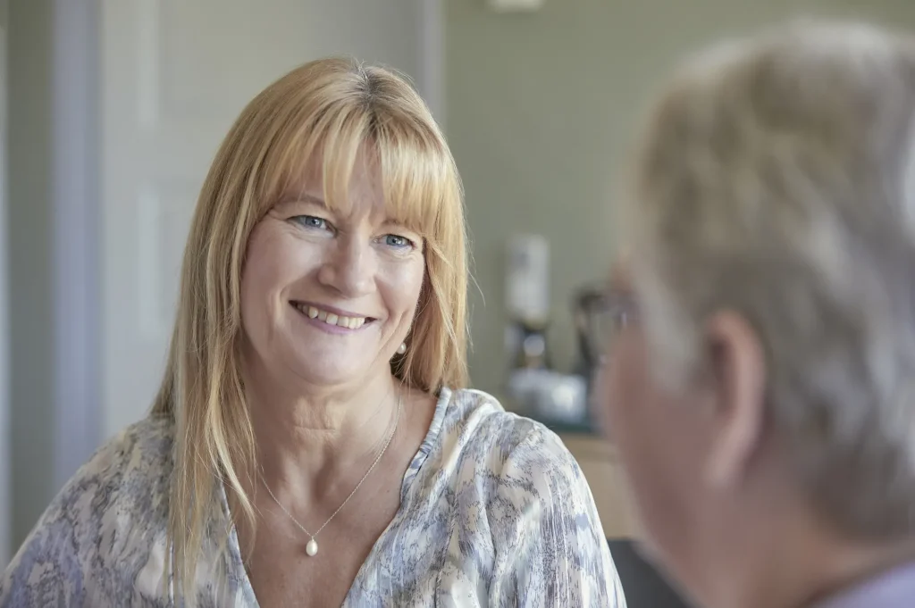 Laila Bill smiler i samtale med en klient