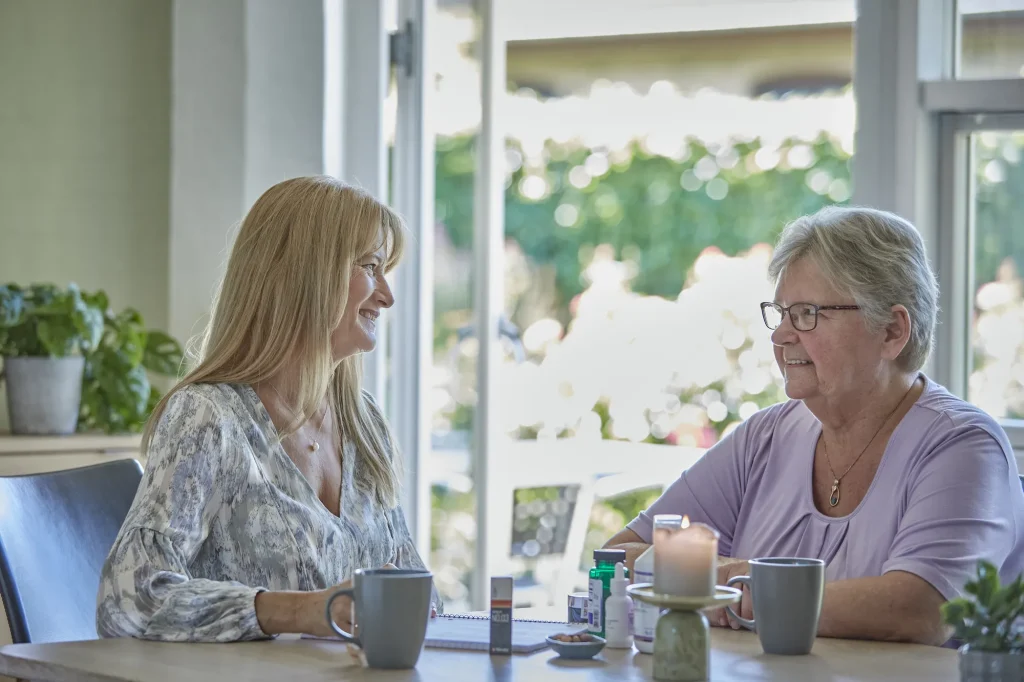 Laila Bill og ældre klient i samtale ved bordet