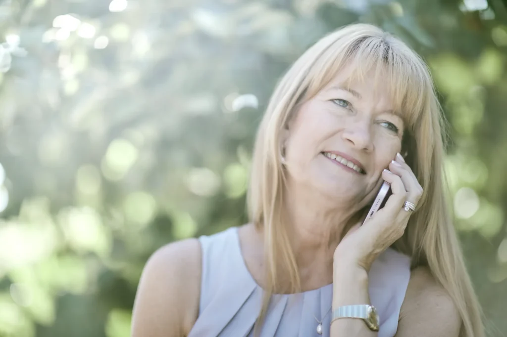 Smilende Laila Bill taler i telefon udendørs