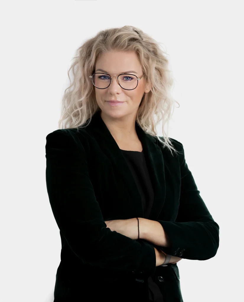 Erhvervsportræt af kvinde med briller og korslagte arme mod hvid baggrund
